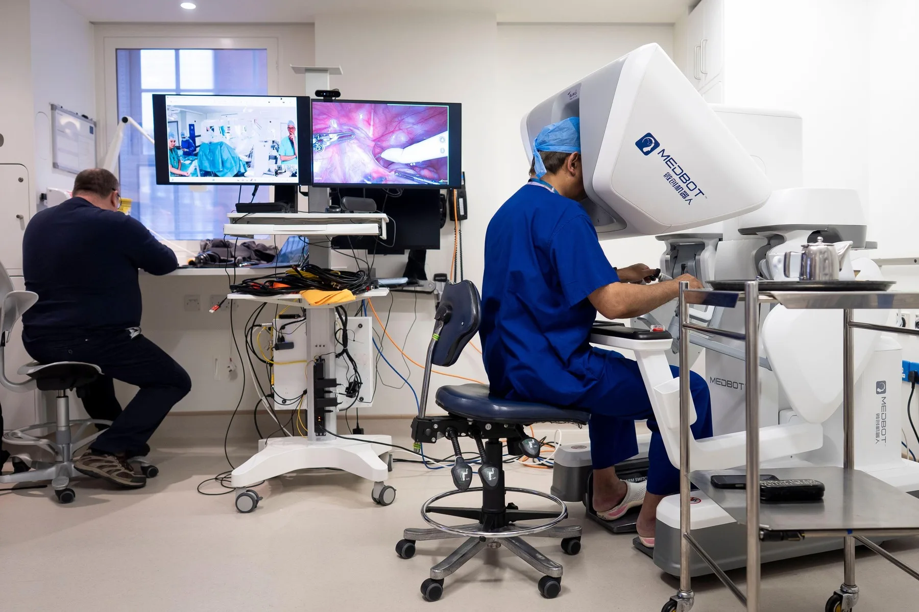 Chirurg controlând de la distanță un robot chirurgical în operație