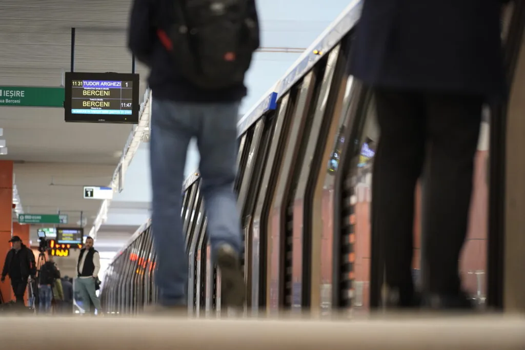 Stație de metrou din București cu călători așteptând pe peron