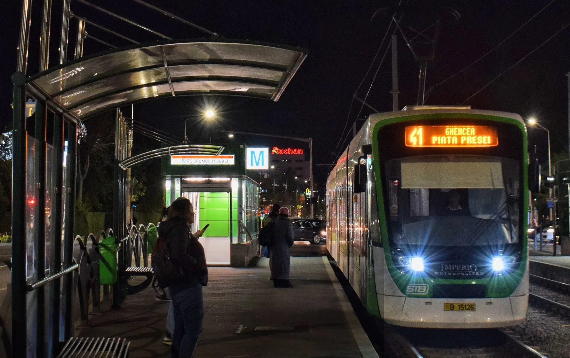 Autobuz STB circulând noaptea pe o stradă iluminată din București de Paște